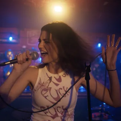 A young woman sings into a microphone